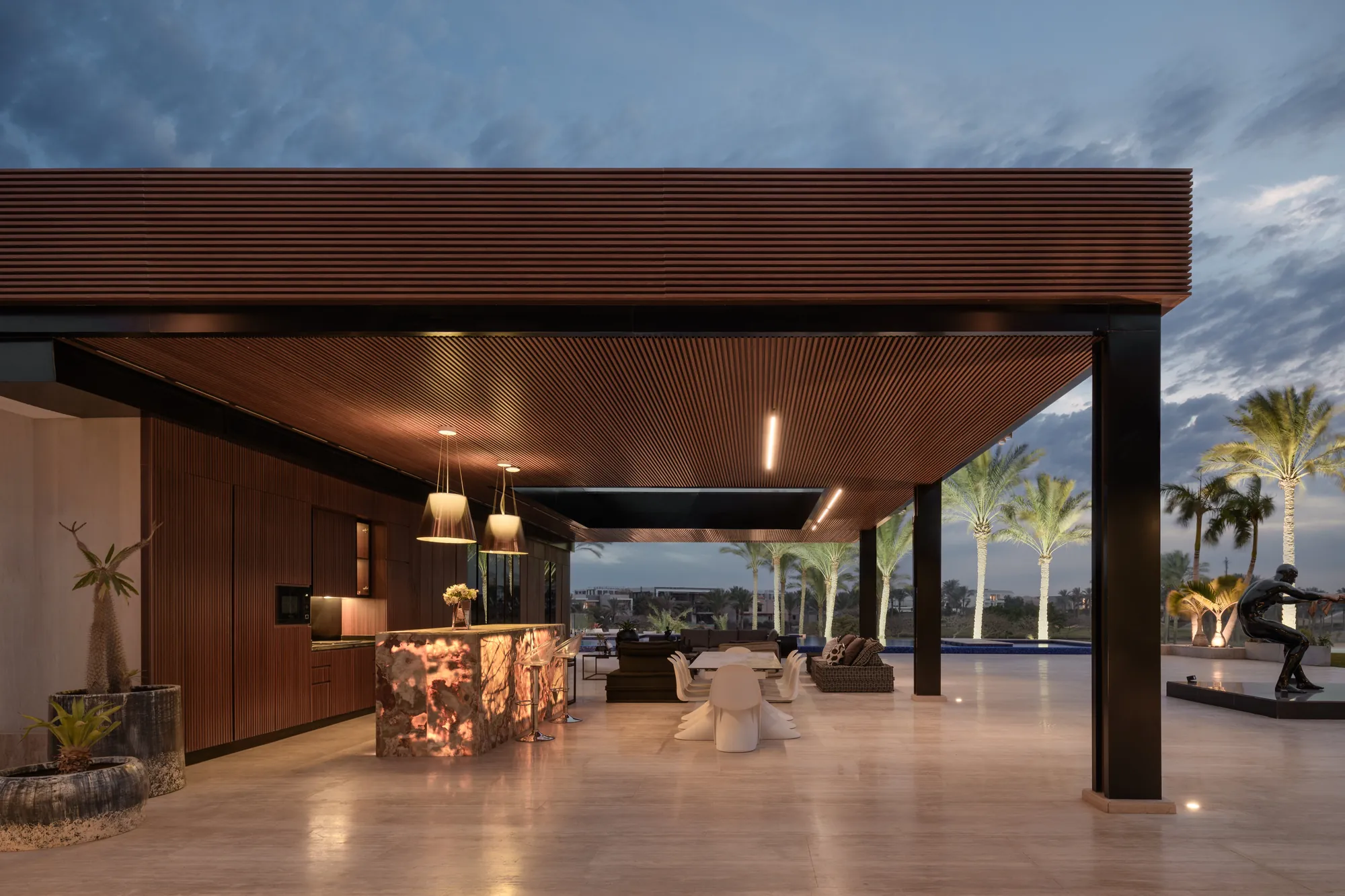 Outdoor pavilion with slatted walnut ceiling at dusk, Katameya Dunes