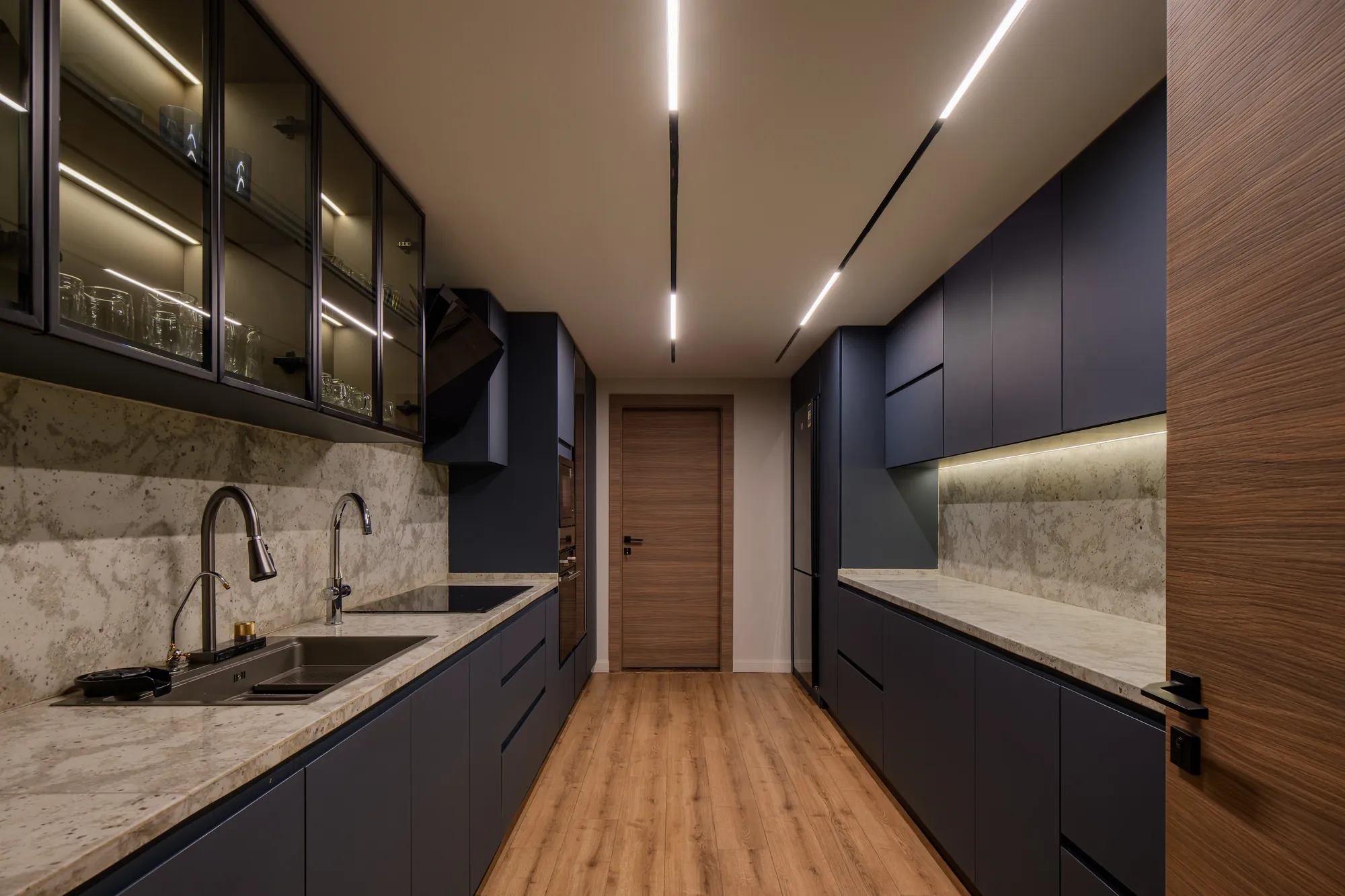 Dark galley kitchen with stone splashback, Palm Hills Residence